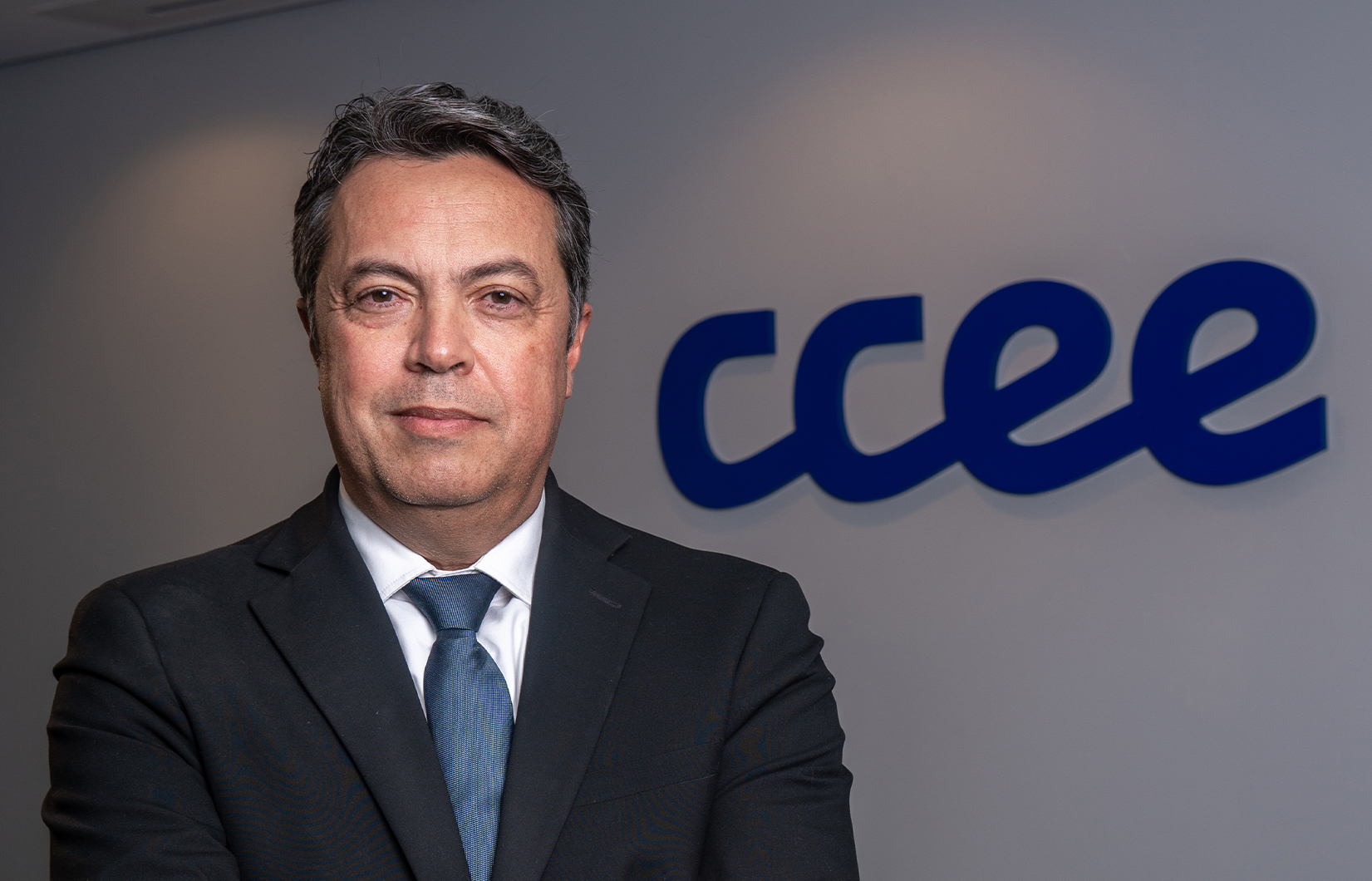Imagem do presidente do Conselho de Administração da CCEE, Alexandre Ramos. Ele é um homem branco, que veste um terno preto, com camisa branca e gravata azul.